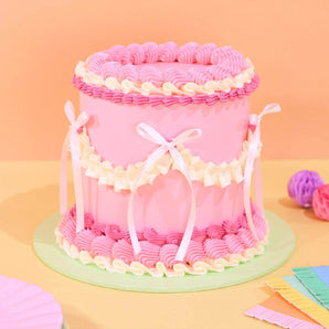 Vintage Cake - Tonal Colour by Crumbs & Doilies with pink Swiss Meringue icing and decorative white ribbons.